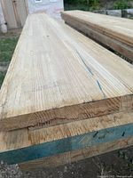 Stacked hardwood boards showing thickness and width