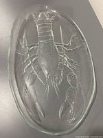 Top view of oval clear glass platter with raised lobster design