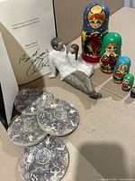 All items grouped: signed book, figurine, nesting dolls, coasters