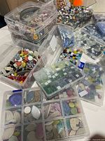 Multiple clear plastic organizers filled with assorted mosaic tiles
