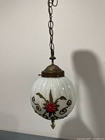 Full view of hanging glass globe light with chain