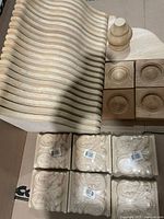 Stack of curved ribbed moulding strips, rosette blocks, finial, carved blocks visible