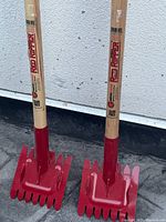 Two Red Ripper shingle strippers standing upright showing full length