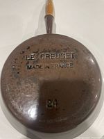 Bottom of skillet showing Le Creuset Made in France and 24 marks, brown enamel wear