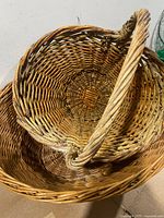 Two nested oval wicker baskets showing interior weave and handles
