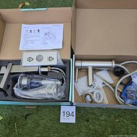two faucets in boxes with hoses, drains and hardware