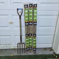 Full view of three bamboo stake packs and garden pitchfork