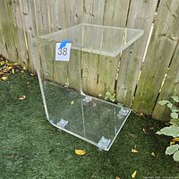 Full view of acrylic C-shaped table on grass