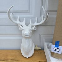 Front view of white deer head wall decor showing overall form and antlers