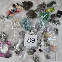 Overview of full lot showing numerous bags of charms, beads, cabochons and findings