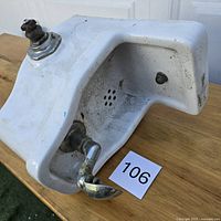 Overall view of porcelain drinking fountain showing spout, basin, and drain