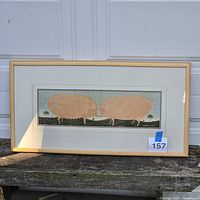 Full view of framed pig print on bench