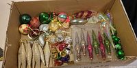 Cardboard box showing majority of assorted ornaments