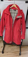 Front view of red True North raincoat on hanger