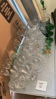 top view of mixed clear and green glassware laid out on table