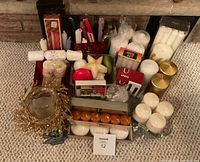 Overview of assorted candles, holders and packaging