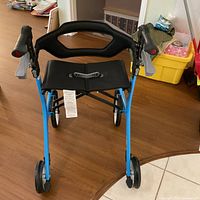 Front angled view showing blue frame, seat, brake handles and wheels