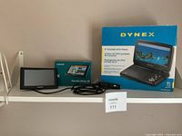 Garmin Drive 50 GPS unit with cable and box, Dynex portable DVD player box on shelf