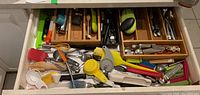 Drawer containing assorted stainless steel and plastic kitchen utensils and gadgets