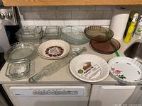 Overview of all pie plates, glass baking dishes and rolling pin on counter