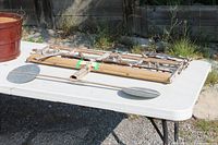 Whirligig folded on table showing full bamboo frame and metal paddles