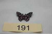 Front view of butterfly brooch showing pink stones