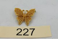 Front view of gold-tone filigree butterfly brooch