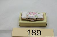 Closed lipstick case showing porcelain floral top