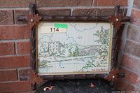 Full view of embroidered artwork in frame against brick wall