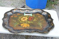 Front view of large black scalloped toleware tray with floral painting