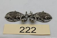 Front view of two-piece metal belt buckle showing grape motif and clasp