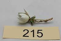 Full view of white enamel rosebud brooch beside lot card 215