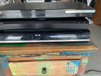 Front view of three stacked players showing brands and disc formats