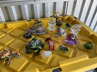 Group shot of all frog figurines on yellow surface