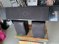 Front view JBL center atop two Infinity bookshelf speakers
