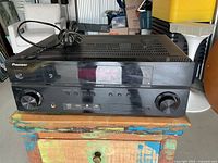 Front three-quarter view of Pioneer receiver showing overall condition and attached power cord
