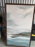 Full view of framed abstract canvas leaning against wall