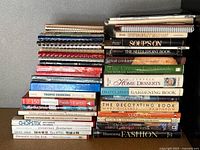 Two tall stacks of assorted books showing spines