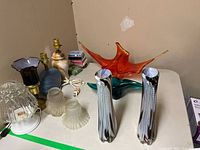 Overall lot on table showing vases, centerpiece, ashtray, lamps, playing cards