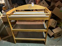 Front view of wooden baby changing table with three shelves