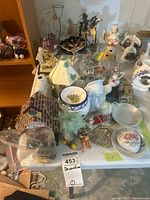 Table view showing assorted candle holders, figurines, potpourri jar, ornaments and other décor