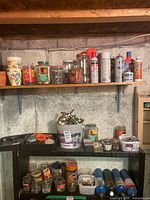 Shelves with drill accessories, propane cylinders, jars of screws, cleaners and spray paint