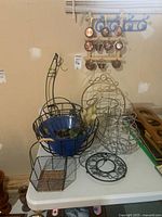 All items on table including racks, baskets, trivet and copper dishes on wall rack