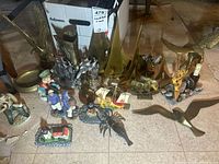 Overall lot showing brass birds, sailboats, boot, lobster and ceramic figurines