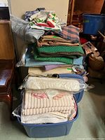 Stack of assorted textiles on blue storage bin