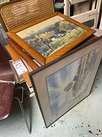 Stack of framed prints showing variety of frame styles and sizes