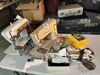 Both Singer sewing machines on table with accessories visible