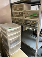Tower drawer unit beside metal shelf with five shallow units