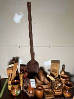 Overall lot layout with 39" spoon, mills, bowls, utensils, stein, goblets, liquor box