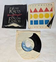 Front view of three singles showing labels and sleeves